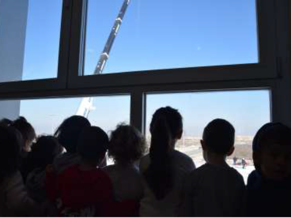 Alumnos viendo trabajos de construcción desde ventana