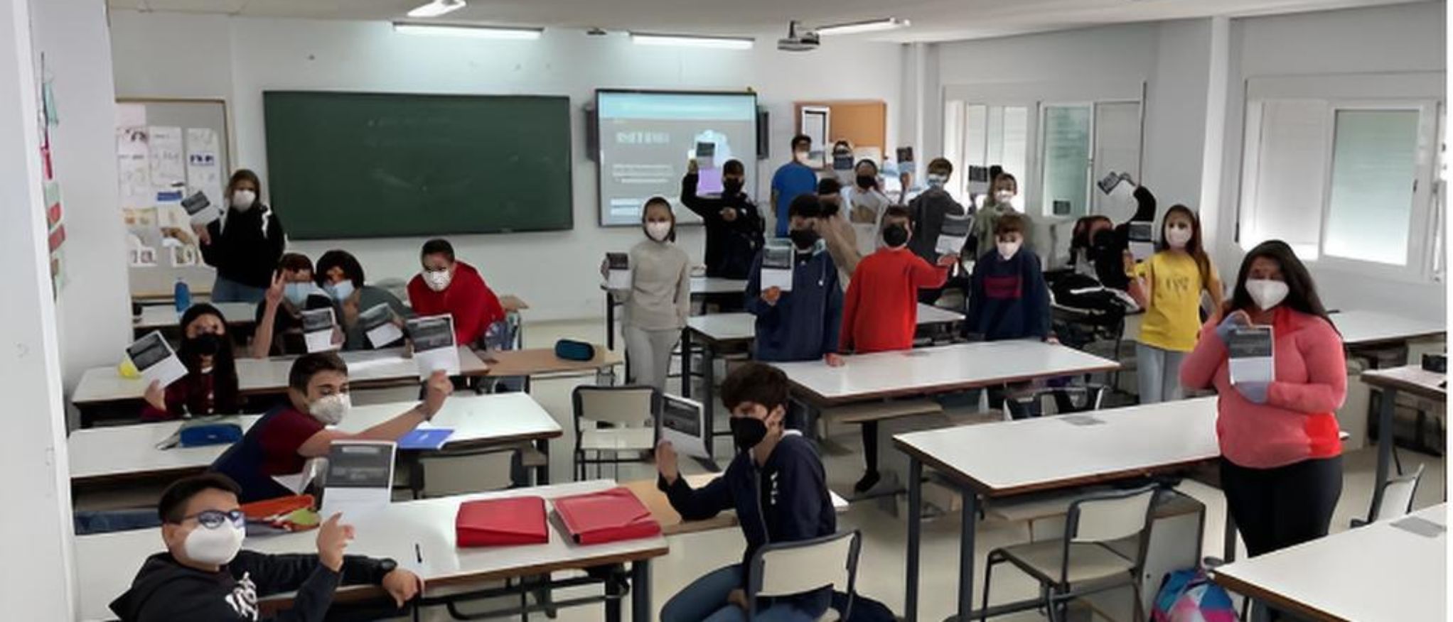 Alumnos en aula con pantalla para visionado de vídeos